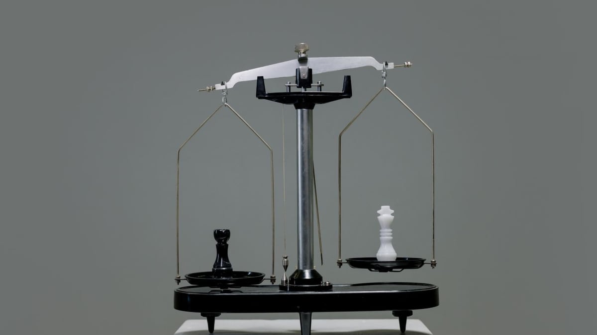 Black rook and white king chess pieces balanced on the pans of a laboratory scale